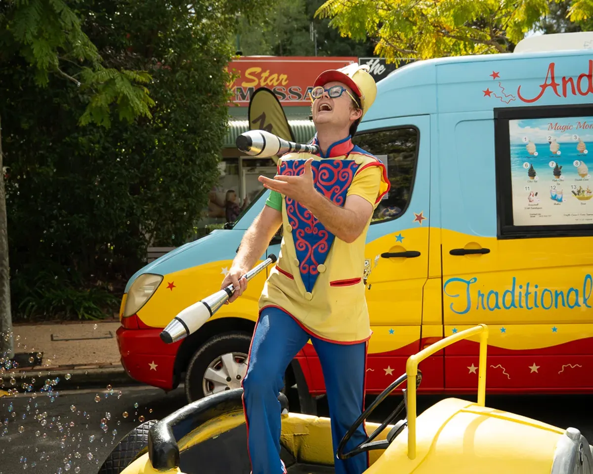 A juggler performing beside the Andersons' Ices ice cream van at the Mudgeeraba street party, Gold Coast