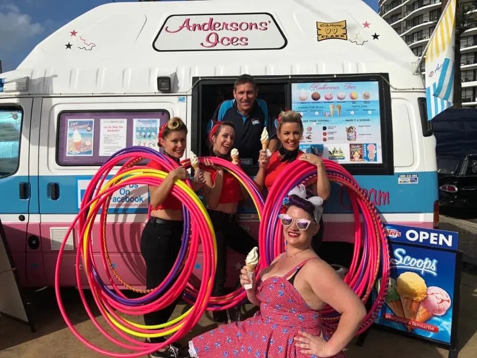 Retro pin-up performers with hula hoops beside the Andersons' Ices van at Cooly Rocks On, Coolangatta